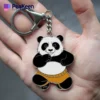 Close-up of a hand displaying a soft enamel panda bear keychain, highlighting its adorable features and craftsmanship.