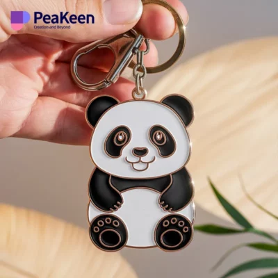 A soft enamel panda keychain is held up against a palm tree backdrop, highlighting its cute features and craftsmanship.