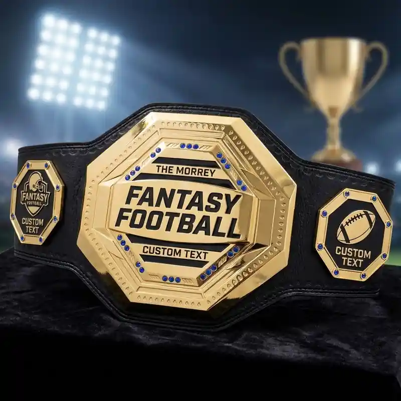Gold custom fantasy football champion belt with personalized text plates, displayed in a stadium trophy setting