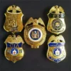 Un grupo de cuatro insignias con las palabras "CIA" y "FBI" bien visibles.
