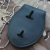 Funda de cuero negro con dos agujeros, que contiene una placa del FBI, indicativa de identificación oficial.