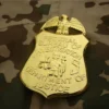 Una insignia dorada del FBI pegada a una chaqueta de camuflaje.