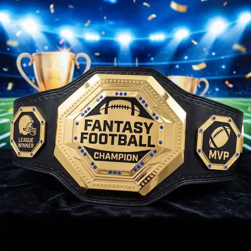 Gold fantasy football champion belt with League Winner and MVP side plates, displayed in a stadium celebration scene