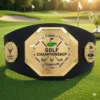 Gold golf championship champion belt with Lowest Score and Hole in One side plates, displayed on a golf course