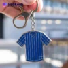 A blue jersey keychain adorned with a blue stripe, combining functionality with a sporty aesthetic.