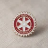 Eine rot-weiße Rotaract-Anstecknadel, auf der das Wort "Rotary" gut sichtbar ist.