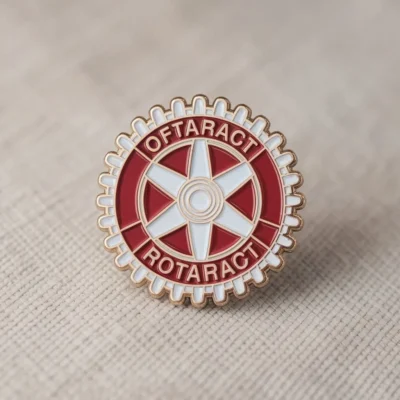 A red and white Rotaract pin featuring the word "Rotary" prominently displayed.