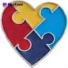 Heart-shaped puzzle piece with four colorful segments, symbolizing autism awareness and inclusivity.