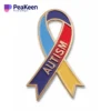 A vibrant autism ribbon pin featuring the word "autism" prominently displayed in colorful design.