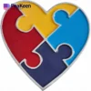 Heart-shaped puzzle piece with four colorful segments, symbolizing autism awareness and acceptance.