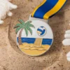 Medalla de voley playa, con un balón de playa rodeado de palmeras y un soleado paisaje playero.