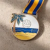 Medalla con un balón de voleibol y una palmera, símbolo de los logros en el voley playa.