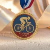 自転車競技での功績を象徴するサイクリストをデザインしたゴールドメダル。
