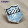 Insigne de club avec un logo personnalisé, réalisé en émail pour une représentation distinctive et colorée de la marque.