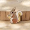 Una curiosa ardilla posada sobre una mesa de madera, agarrando una taza de café, rodeada de un ambiente acogedor.
