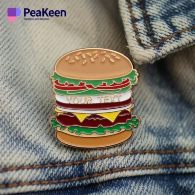 A close-up of a denim jacket adorned with a vibrant hamburger pin, showcasing a playful fashion statement.