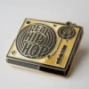 A gold and black enamel pin inscribed with "Real Hip Hop," symbolizing hip hop pride.