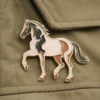 Epingle à cheval représentant un cheval noir et blanc attaché à une veste.