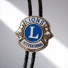 Insignia de Lions International sujeta a un cordón de cuero, diseñada como corbata de bolo para socios del club.