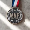 A gold medal engraved with the letters "MVP" prominently displayed on the front.