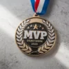 A gold medal featuring the letters "MVP" prominently displayed on its front.