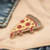 Un alfiler de pizza de colores unido a una chaqueta vaquera, que muestra un accesorio divertido y juguetón.