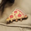 Un alfiler de pizza de colores unido a una chaqueta vaquera, que muestra un accesorio divertido y juguetón para los amantes de la pizza.