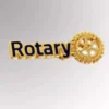 Pin de solapa dorado con la palabra "Rotary", símbolo de afiliación al Club Rotario.