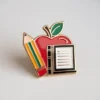 A red apple placed on a book beside a pencil, embodying the essence of teaching and commonly associated with educators.