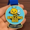 Custom logo medal for a spelling bee, featuring intricate design and text highlighting the event's name.