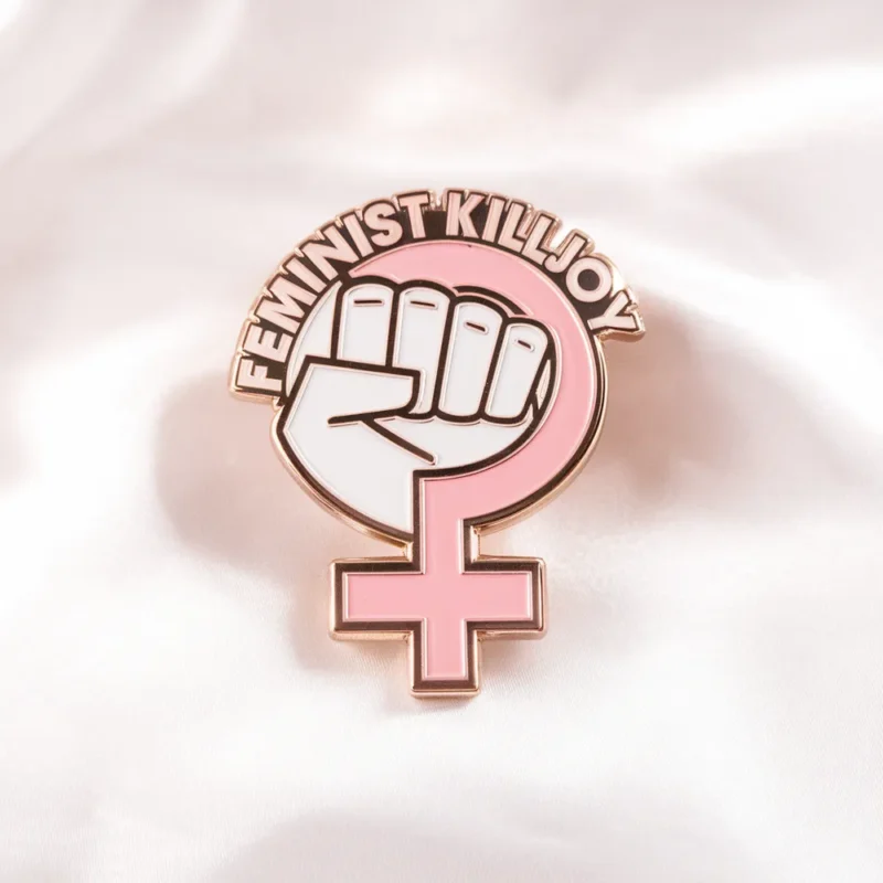 Enamel pin featuring the phrase "Feminist Killjoy" in bold lettering, symbolizing feminist activism and resistance.