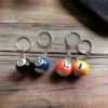 A keychain featuring three billiard balls, each marked with a number, perfect for billiards fans and collectors.