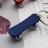 Blue skateboard keychain with a red and white accent, featuring a metal design for durability and style.