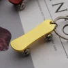 Yellow skateboard-shaped keychain with a keyring, designed for easy attachment to bags or keys.