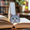 A cat-shaped bookmark rests on an open book, adding a whimsical touch to the reading experience.