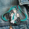A pin featuring a girl in a blue shirt and tie, inspired by the character Miku.