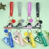 A collection of colorful key chains, including a distinctive PVC Nike keychain among various designs.