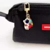 A small black bag featuring an astronaut keychain charm attached to it.