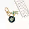 Keychain featuring a green and white astronaut charm, set against a space-themed background.