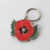 Enamel keychain featuring a vibrant red poppy flower, symbolizing remembrance and beauty.
