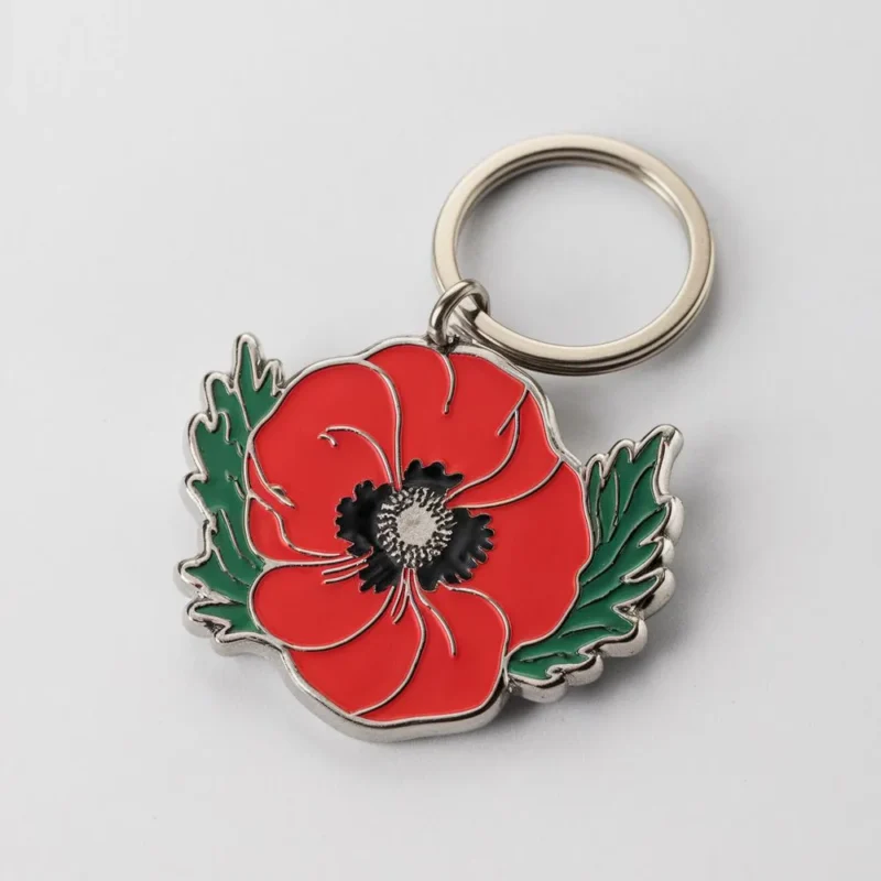 Enamel keychain featuring a vibrant red poppy flower, symbolizing remembrance and beauty.