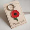 Enamel poppy keyring featuring a vibrant red poppy design, perfect for adding a touch of remembrance to your keys.