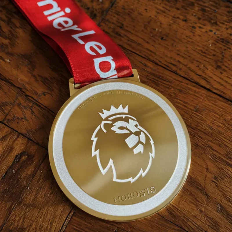 A gold medal featuring a lion design, representing achievement in enamel soccer competitions.