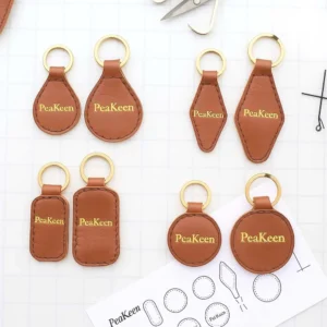 Several embossed leather keychains, each embossed with the word "peakeen," arranged together.