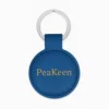 Round keychain in blue, crafted from embossed leather, offering a personalized touch and elegant appearance.