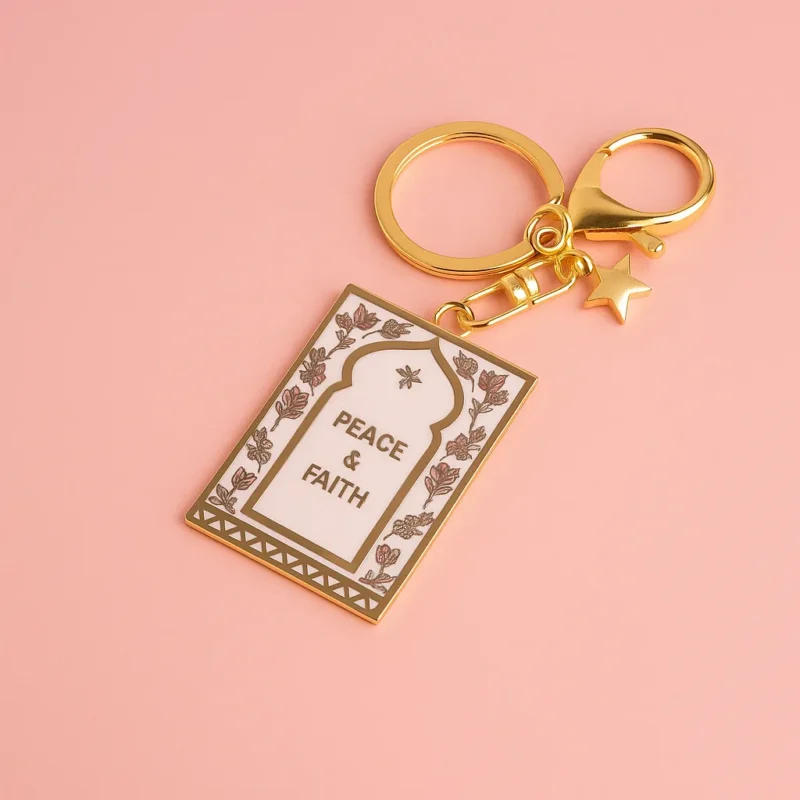 Gold keychain featuring a peace message in Islam, designed as a prayer mat keychain.