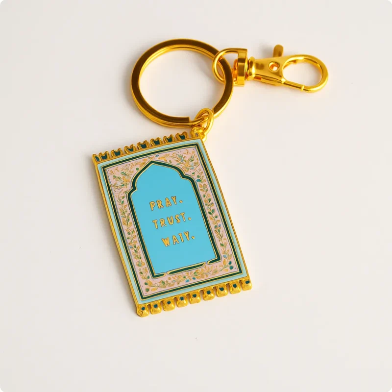 Gold keychain featuring a peace message in Islam, designed as a prayer mat keychain.