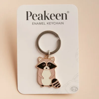 A cute raccoon keychain featuring a playful design, perfect for adding charm to your keys or bag.