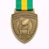 A gold League Challenge Cup Winners 2026 medal featuring a rugby ball passing through goal posts, framed by laurel wreaths, with a green and yellow ribbon.