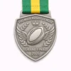 A silver Premier Rugby League Grand Final 2026 medal featuring a rugby ball with wings, laurel wreaths, and a crown, suspended from a green and yellow ribbon.
